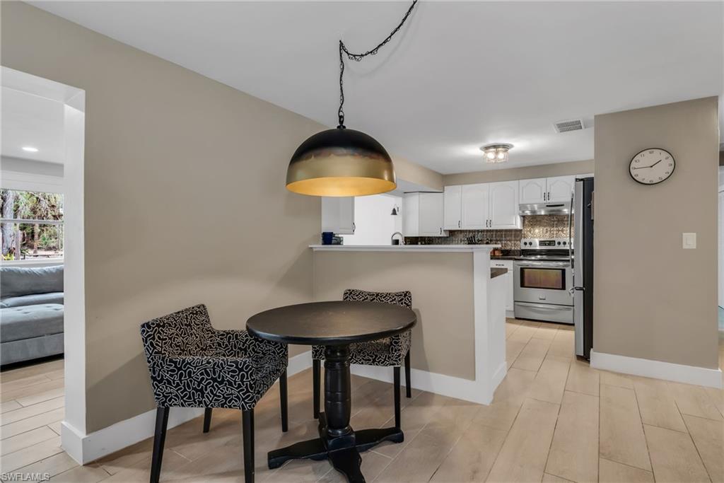 1840 23rd Street Southwest Naples, FL 34117 - Photo 16 of 50 Breakfast area featuring pendant light and light wood plank porcelain tile flooring
