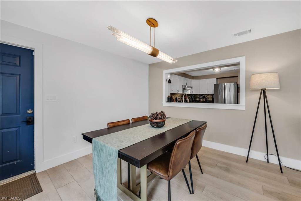 1840 23rd Street Southwest Naples, FL 34117 - Photo 20 of 50 Dining area featuring pendant light and light wood plank porcelain tile flooring