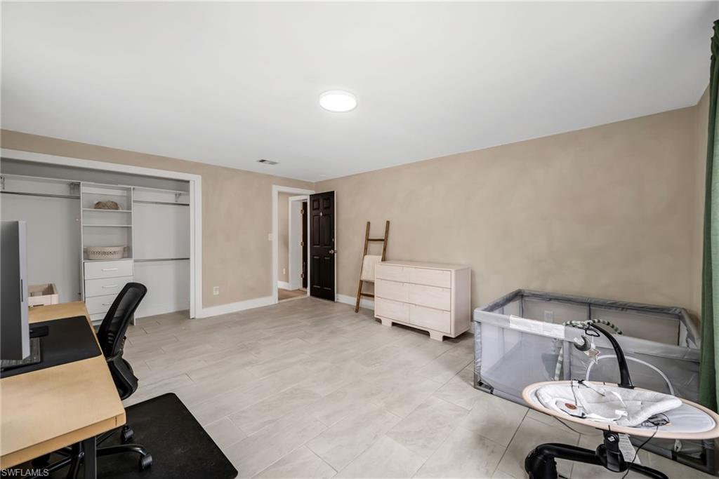 1840 23rd Street Southwest Naples, FL 34117 - Photo 30 of 50 2 Guest bedroom featuring limewash paint and tile flooring