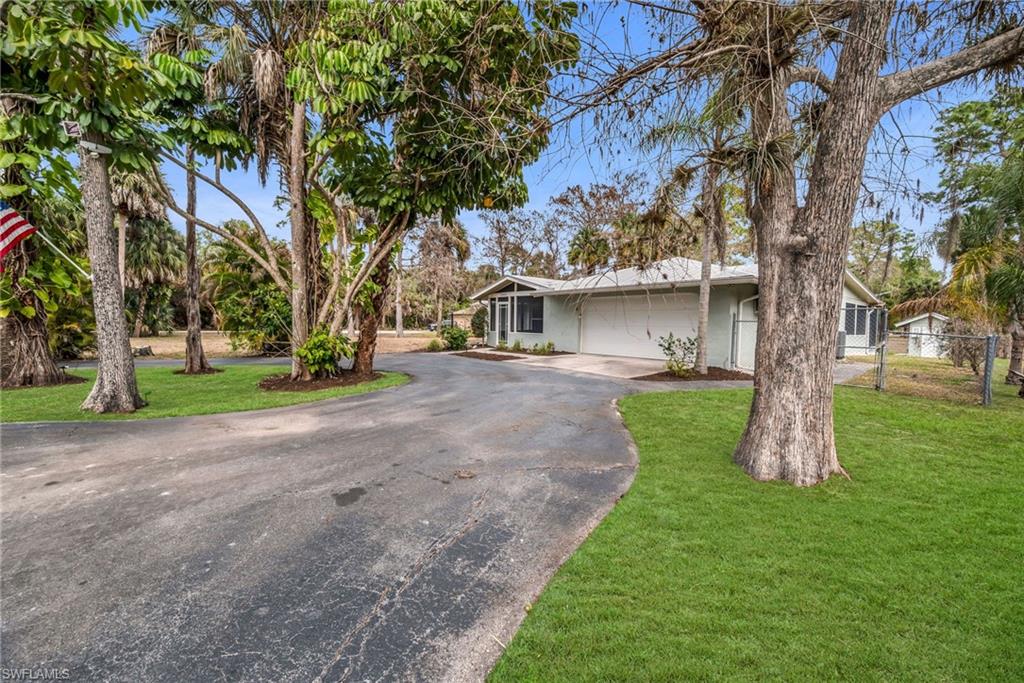 1840 23rd Street Southwest Naples, FL 34117 - Photo 3 of 50 View of front facade with asphalt driveway, an attached garage, a gate, and stucco siding