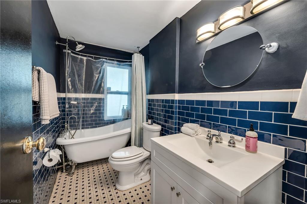 1840 23rd Street Southwest Naples, FL 34117 - Photo 32 of 50 Bathroom featuring tile walls, vanity, a combined bath / shower claw foot freestanding tub