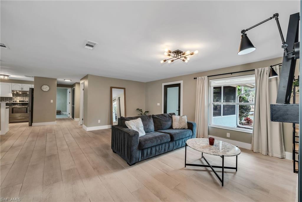 1840 23rd Street Southwest Naples, FL 34117 - Photo 10 of 50 Family room featuring light wood plank porcelain tile flooring