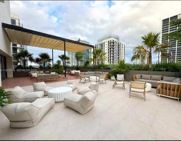 a roof deck with couches and potted plants with sky view