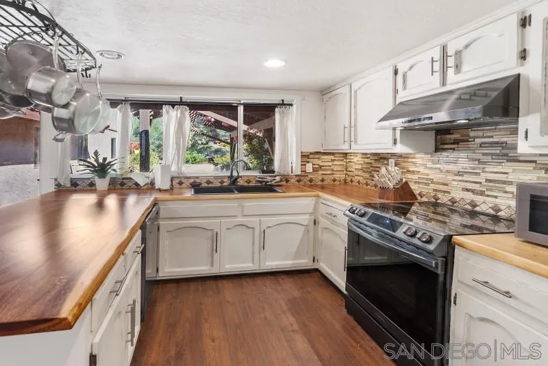 14578 Rios Canyon Road El Cajon, CA 92021 - Photo 7 of 61 a kitchen with stainless steel appliances granite countertop a stove a sink and a microwave