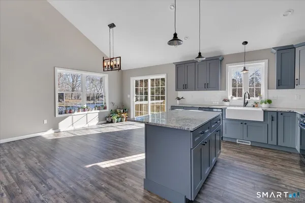 a kitchen with stainless steel appliances granite countertop a sink stove and wooden floor