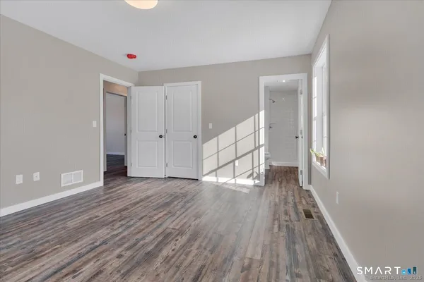 a view of empty room with wooden floor
