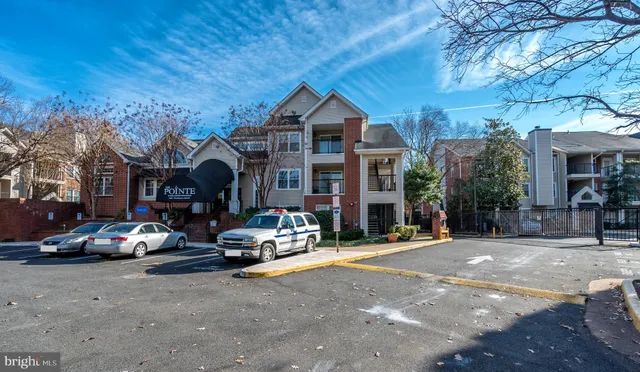 a front view of a building with parked cars