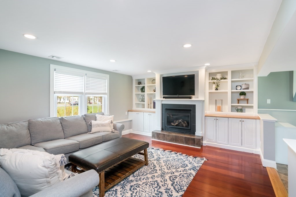 7 Geraldine Lane Braintree, MA 02184 - Photo 16 of 26 a living room with furniture a fireplace and a flat screen tv