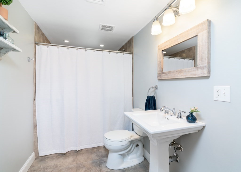 7 Geraldine Lane Braintree, MA 02184 - Photo 19 of 26 a bathroom with a sink mirror and toilet