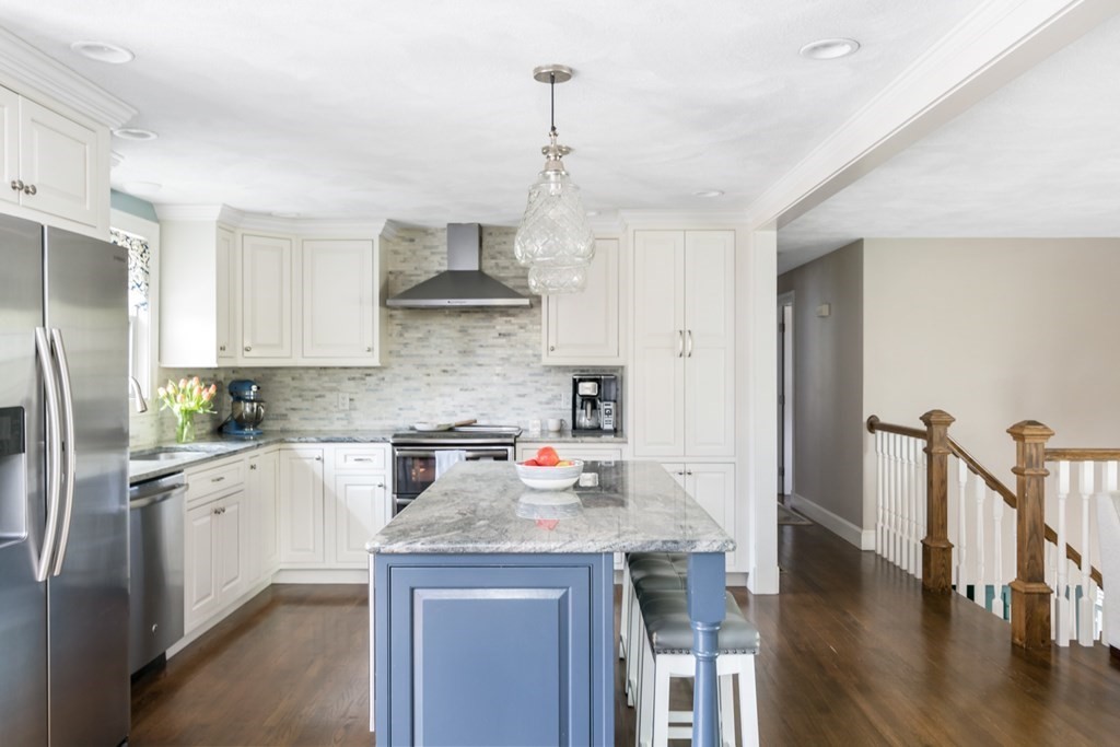 7 Geraldine Lane Braintree, MA 02184 - Photo 8 of 26 a kitchen with stainless steel appliances granite countertop a refrigerator a sink dishwasher a stove and white cabinets with wooden floor