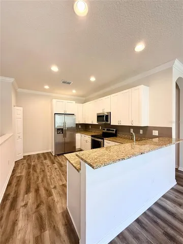 a large kitchen with stainless steel appliances granite countertop a sink and a stove
