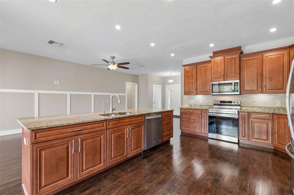 29913 Darby Road Dade City, FL 33525 - Photo 20 of 100 a kitchen with stainless steel appliances granite countertop a stove sink and cabinets