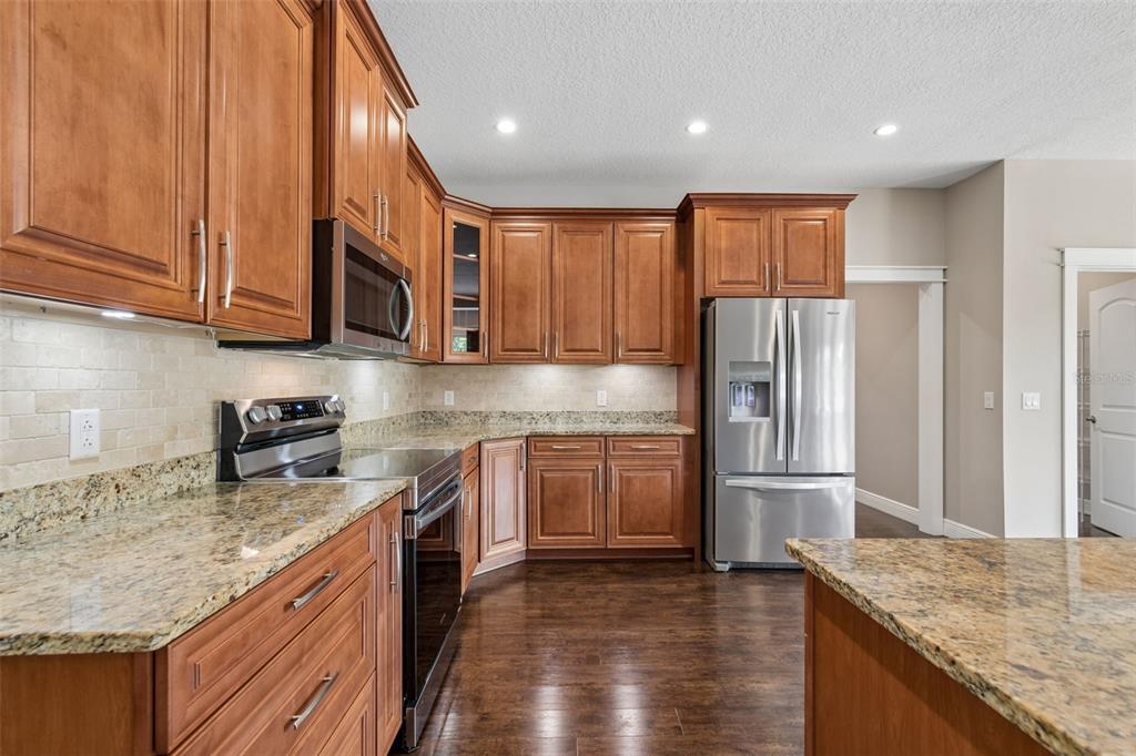 29913 Darby Road Dade City, FL 33525 - Photo 23 of 100 a kitchen with stainless steel appliances granite countertop a refrigerator a stove and a sink