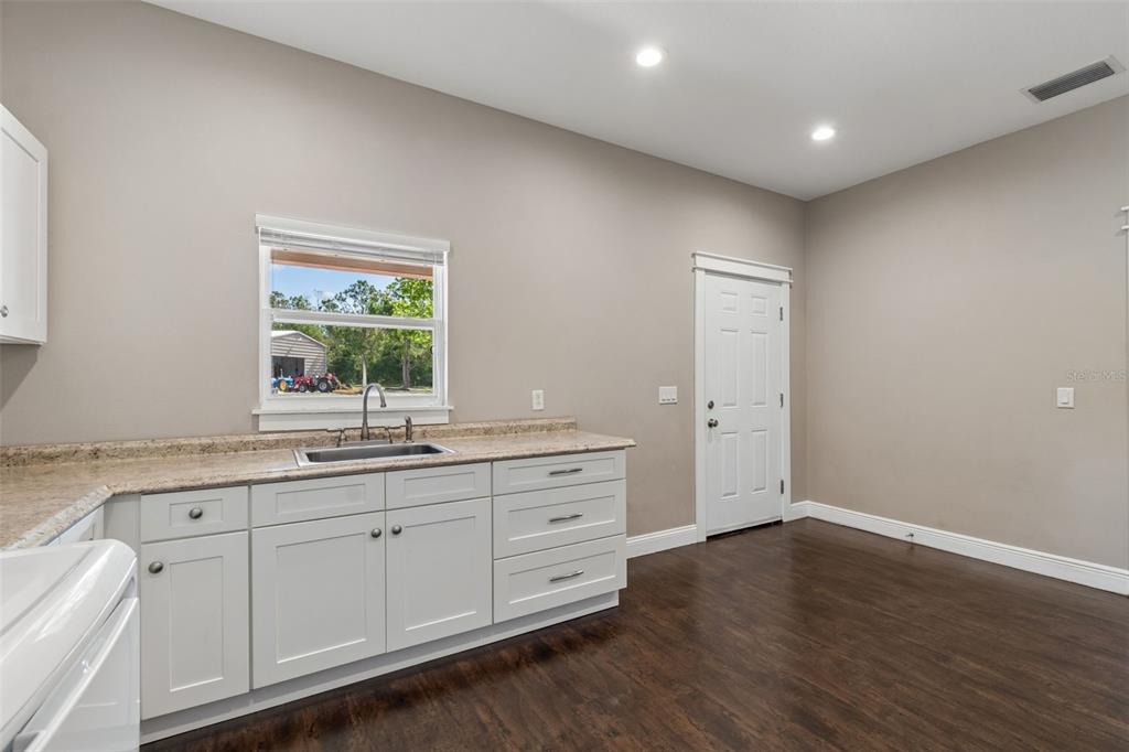29913 Darby Road Dade City, FL 33525 - Photo 33 of 100 a bathroom with a granite countertop sink mirror and window
