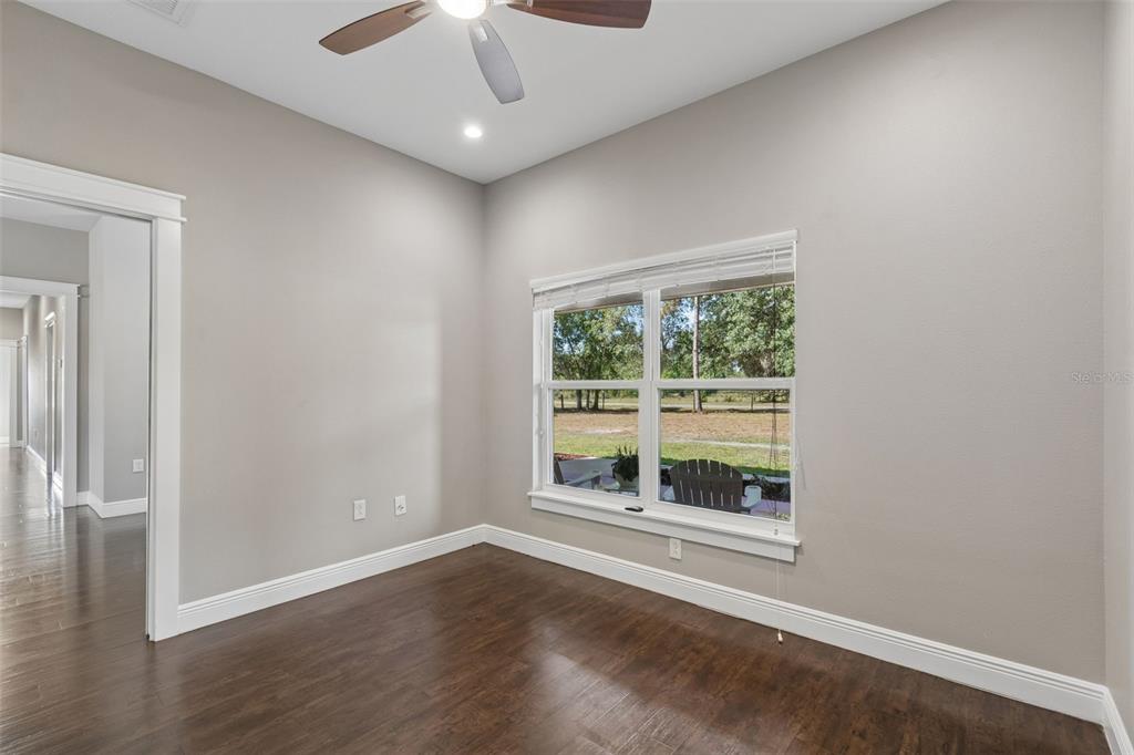29913 Darby Road Dade City, FL 33525 - Photo 35 of 100 an empty room with wooden floor chandelier fan and windows