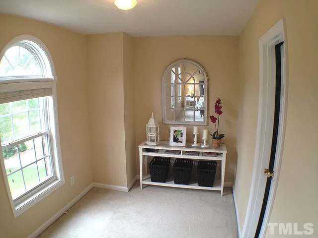 an empty room with a fireplace and windows