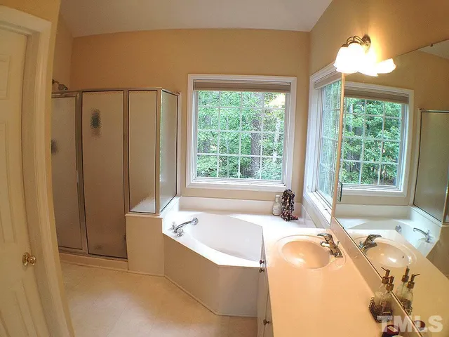 a spacious bathroom with bathtub and shower