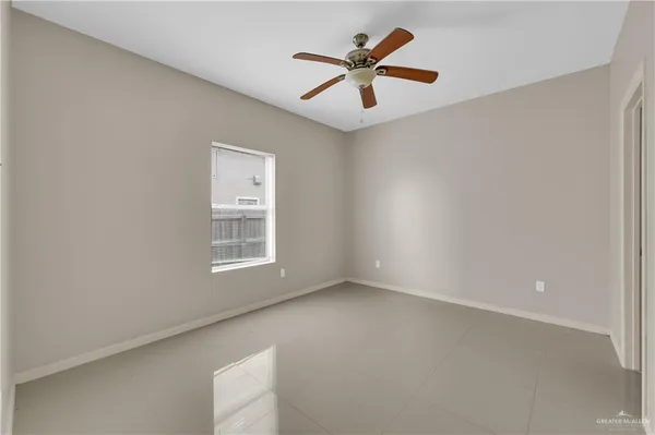 an empty room with a window and a fan