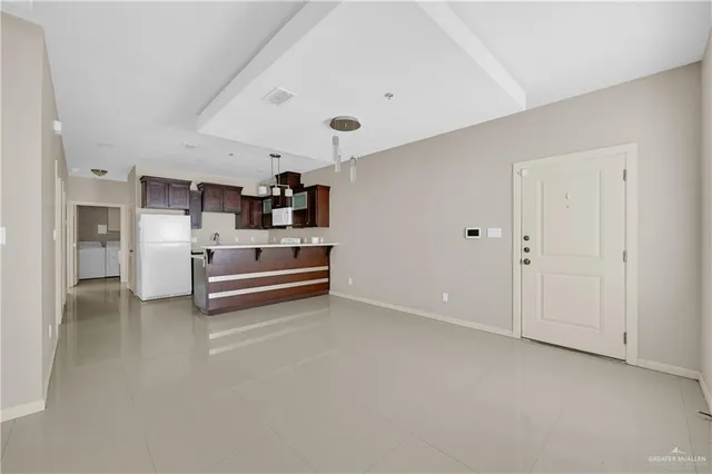a view of kitchen with furniture and refrigerator