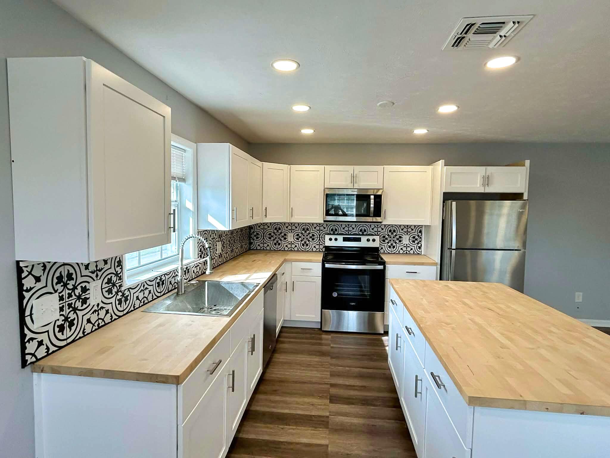 341 Central Avenue, Unit 1 Clewiston, FL 33440 - Photo 2 of 11 a large kitchen with stainless steel appliances granite countertop a lot of counter space and wooden floors