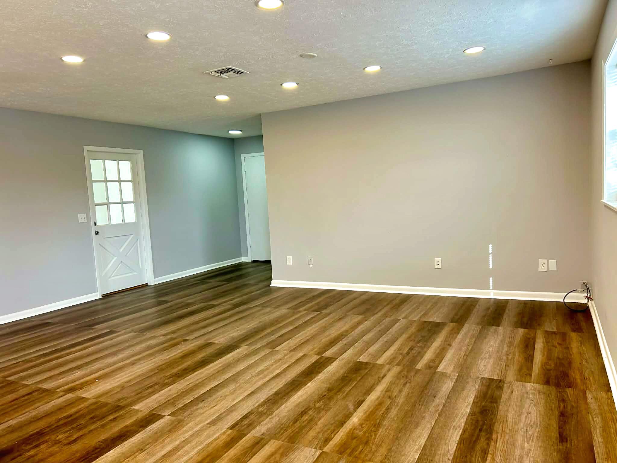 341 Central Avenue, Unit 1 Clewiston, FL 33440 - Photo 3 of 11 an empty room with wooden floor and windows