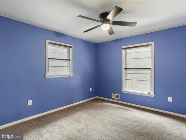 an empty room and chandelier fan