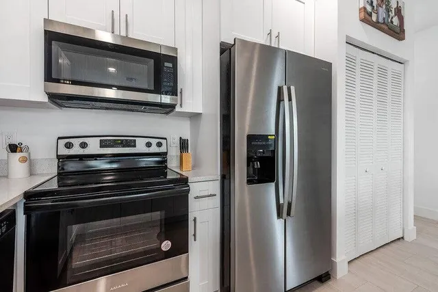 a kitchen with stainless steel appliances a stove microwave and refrigerator