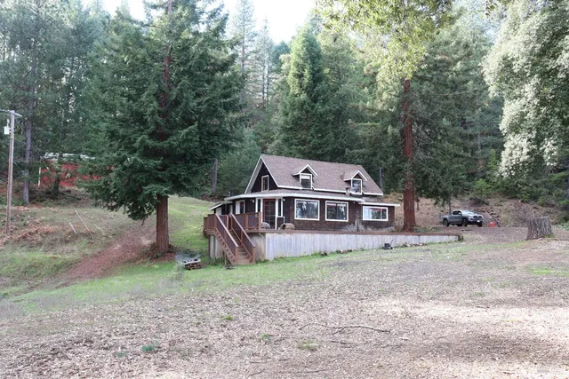 an aerial view of a house with a yard and a tree