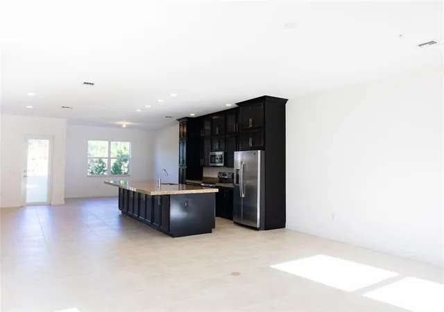a living room with furniture and a refrigerator