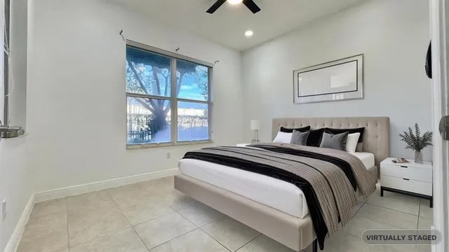 an empty room with windows and fan