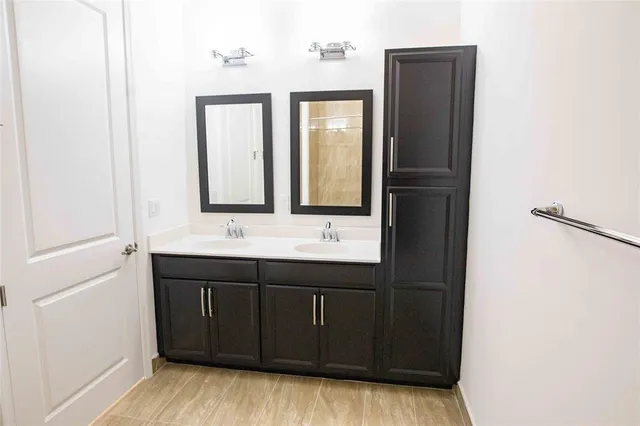 a bathroom with a double vanity sink and mirror