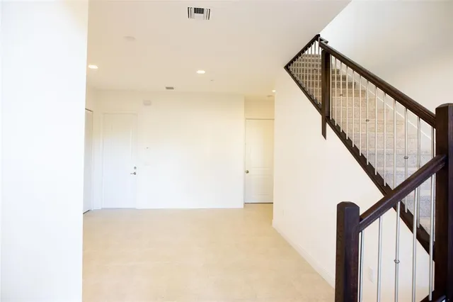 a view of staircase with wooden floor and white walls