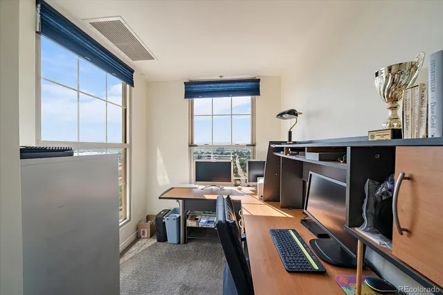 a view of a workspace with furniture and a window