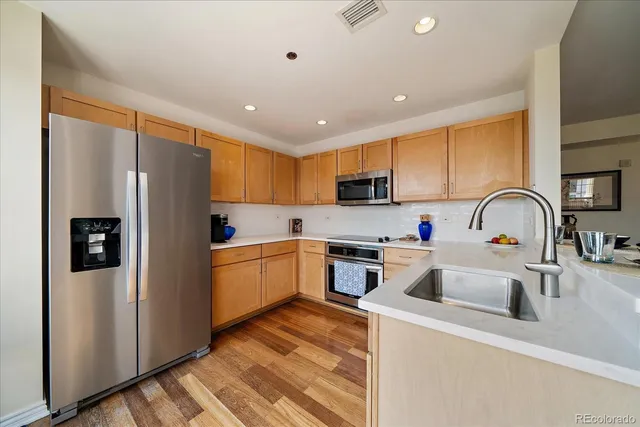 a kitchen with stainless steel appliances granite countertop a refrigerator sink and cabinets