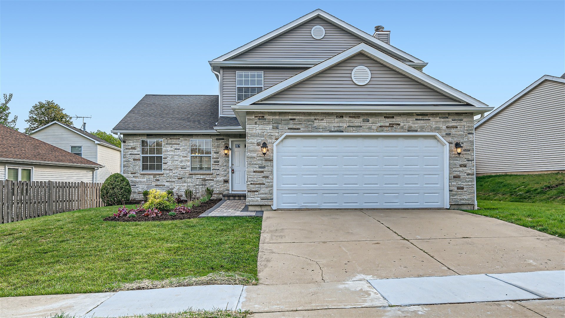 a view of a house with a small yard plants and large tree