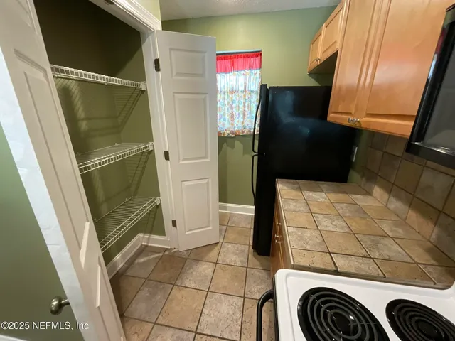 a kitchen with a sink a stove top oven a refrigerator and a window