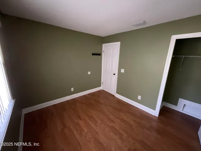 a view of a hallway with wooden floor and stairs