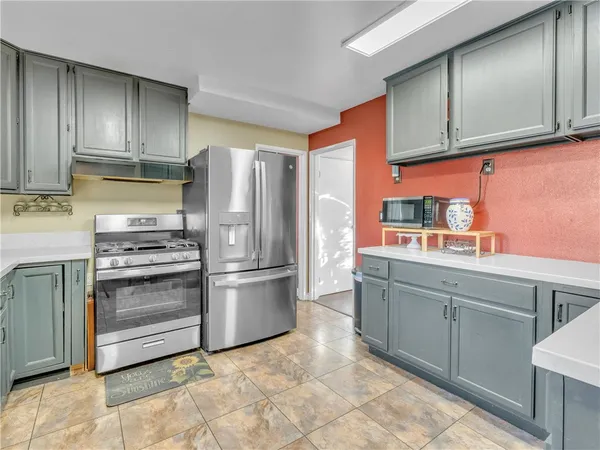 a kitchen with stainless steel appliances granite countertop a refrigerator and a stove top oven