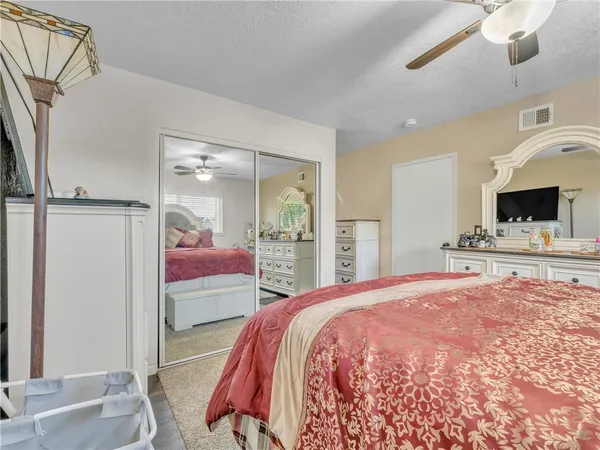 a spacious bedroom with a bed and a flat screen tv
