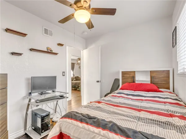 a bedroom with a bed and a computer on the desk