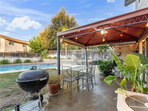 a view of a patio with table and chairs potted plants with wooden fence