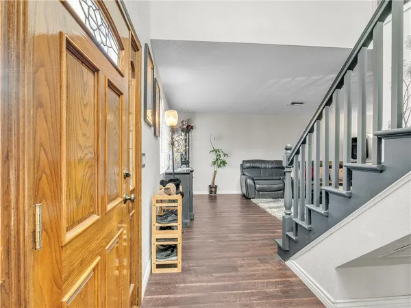 a view of a hallway with wooden floor and staircase