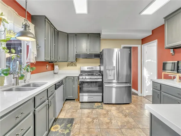 a kitchen with stainless steel appliances a refrigerator sink and stove