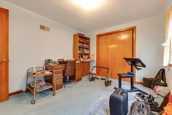 a view of a workspace with furniture and a window