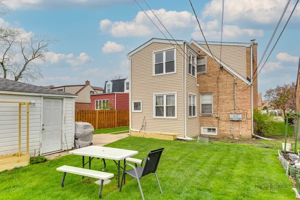 a backyard of a house with table and chairs