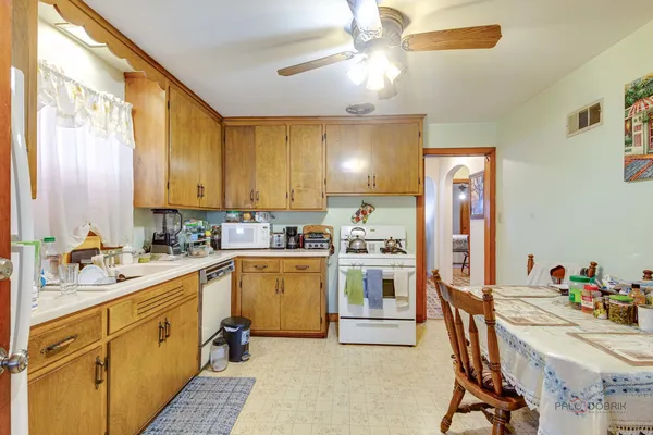 a kitchen with a refrigerator a sink dishwasher a stove and white cabinets with wooden floor