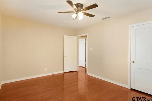 an empty room with a window and a ceiling fan