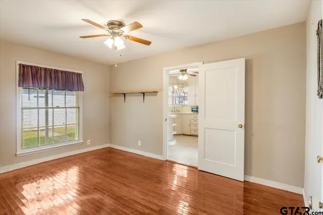 a view of an empty room with window and wooden floor