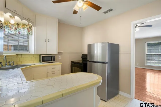 a kitchen with stainless steel appliances a refrigerator sink and cabinets