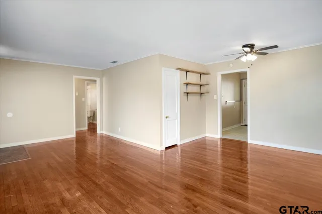 a view of empty room with wooden floor